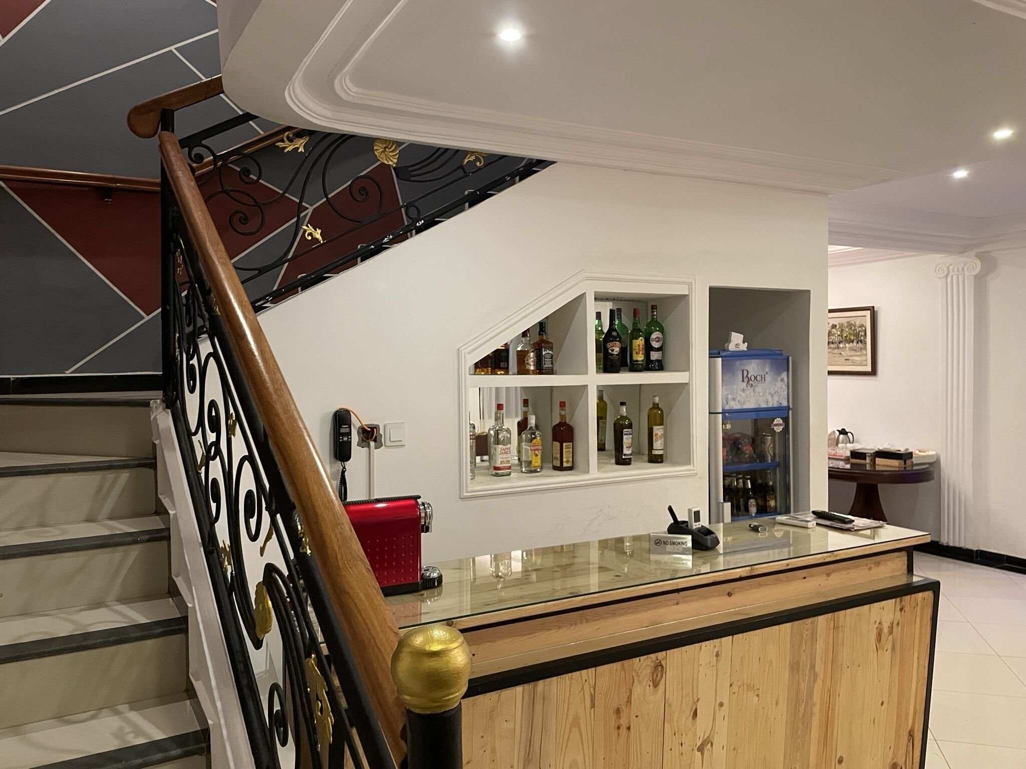 Un escalier avec une rampe en bois et une barrière en verre en bas.