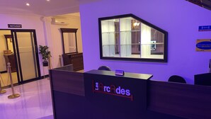 Una mesa de recepción con un cartel de 'No Fumar', un cartel de 'WiFi' y un cartel de 'Restaurante' al fondo.