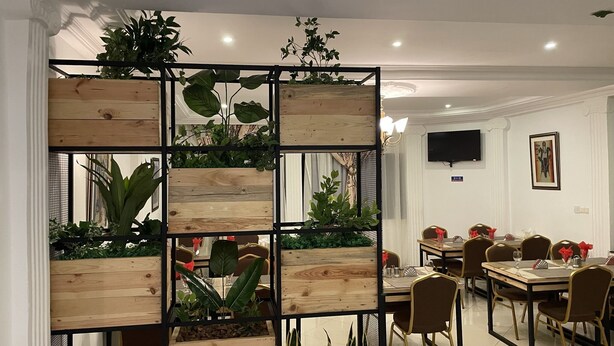 Comedor con separadores de madera, varias mesas y sillas.