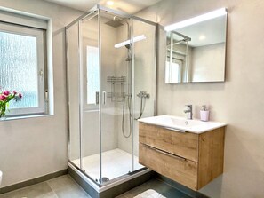 Een douche, handdoeken, zeep, toiletpapier