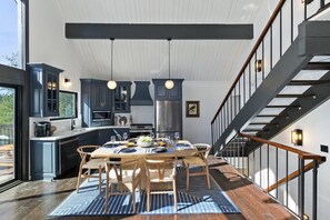 A modern kitchen with dark cabinets, a central island, and pendant lighting.