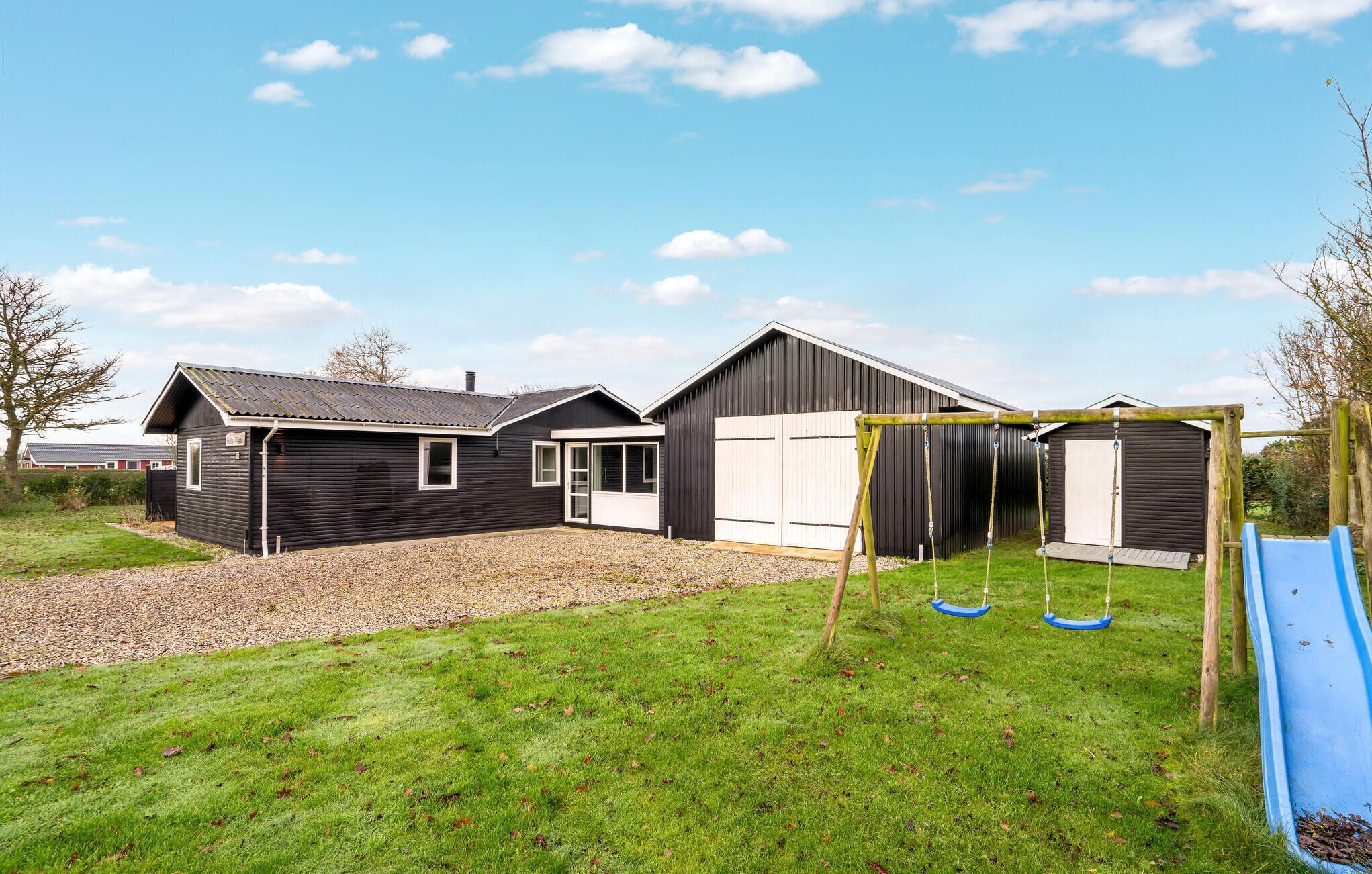 A residential property with a garage, a covered play area, and a blue slide.