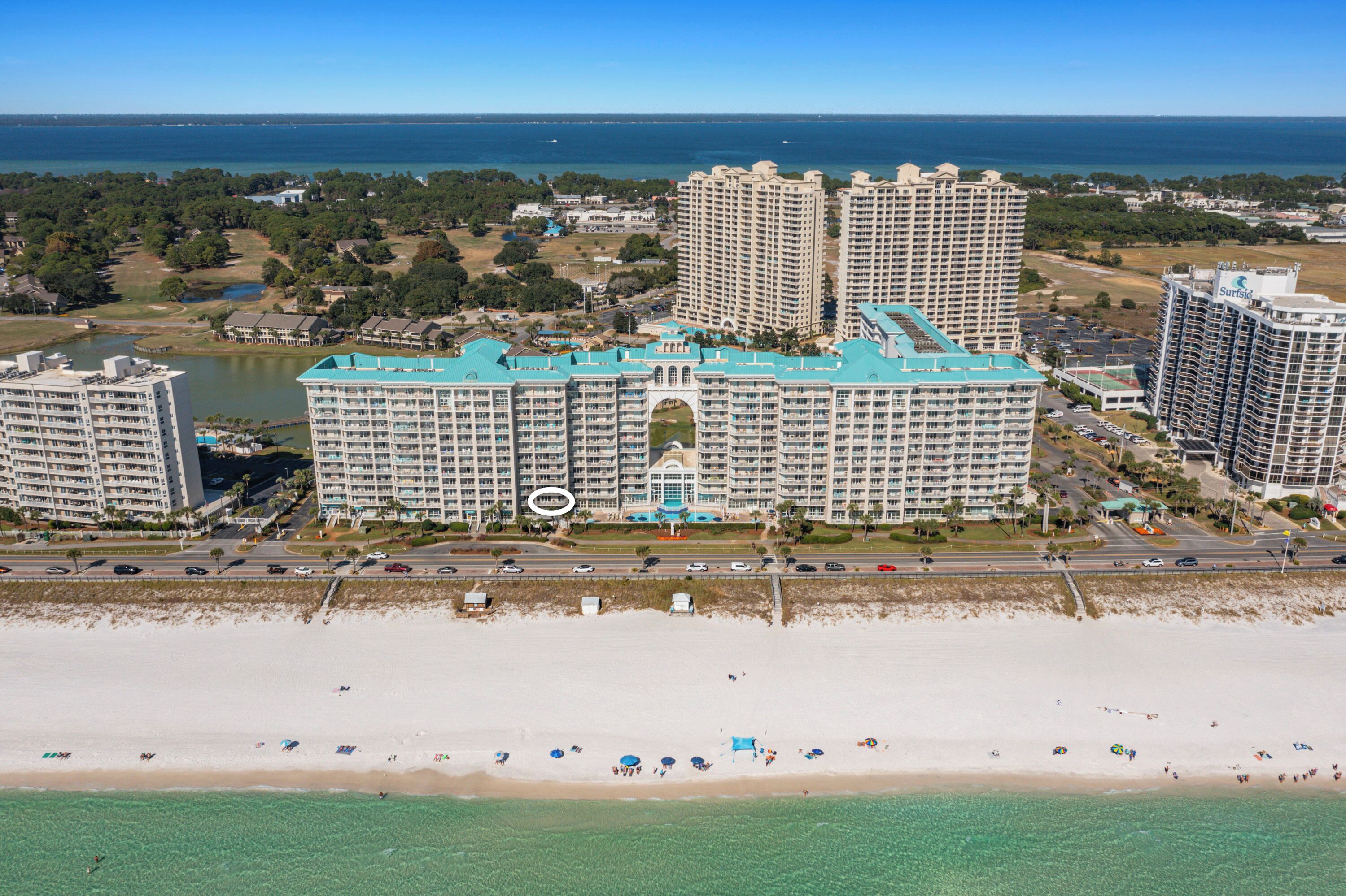 Een groot resort hotel met meerdere hoge gebouwen, een strand en een helder uitzicht op de oceaan.