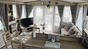Une cuisine compacte avec un coin repas, un téléviseur et un canapé.
