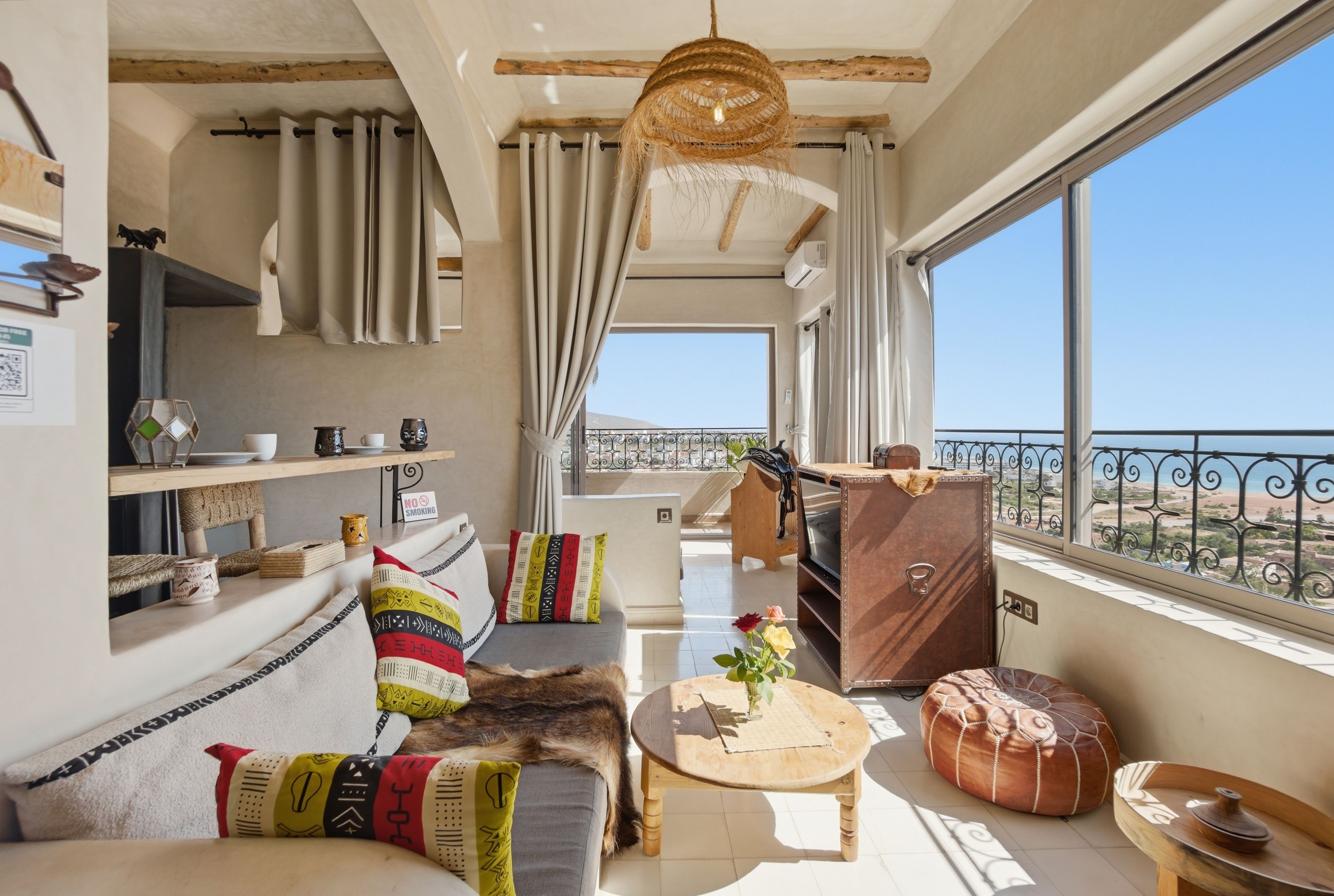 A cozy living area with a sofa, a coffee table, and a view of the sea.