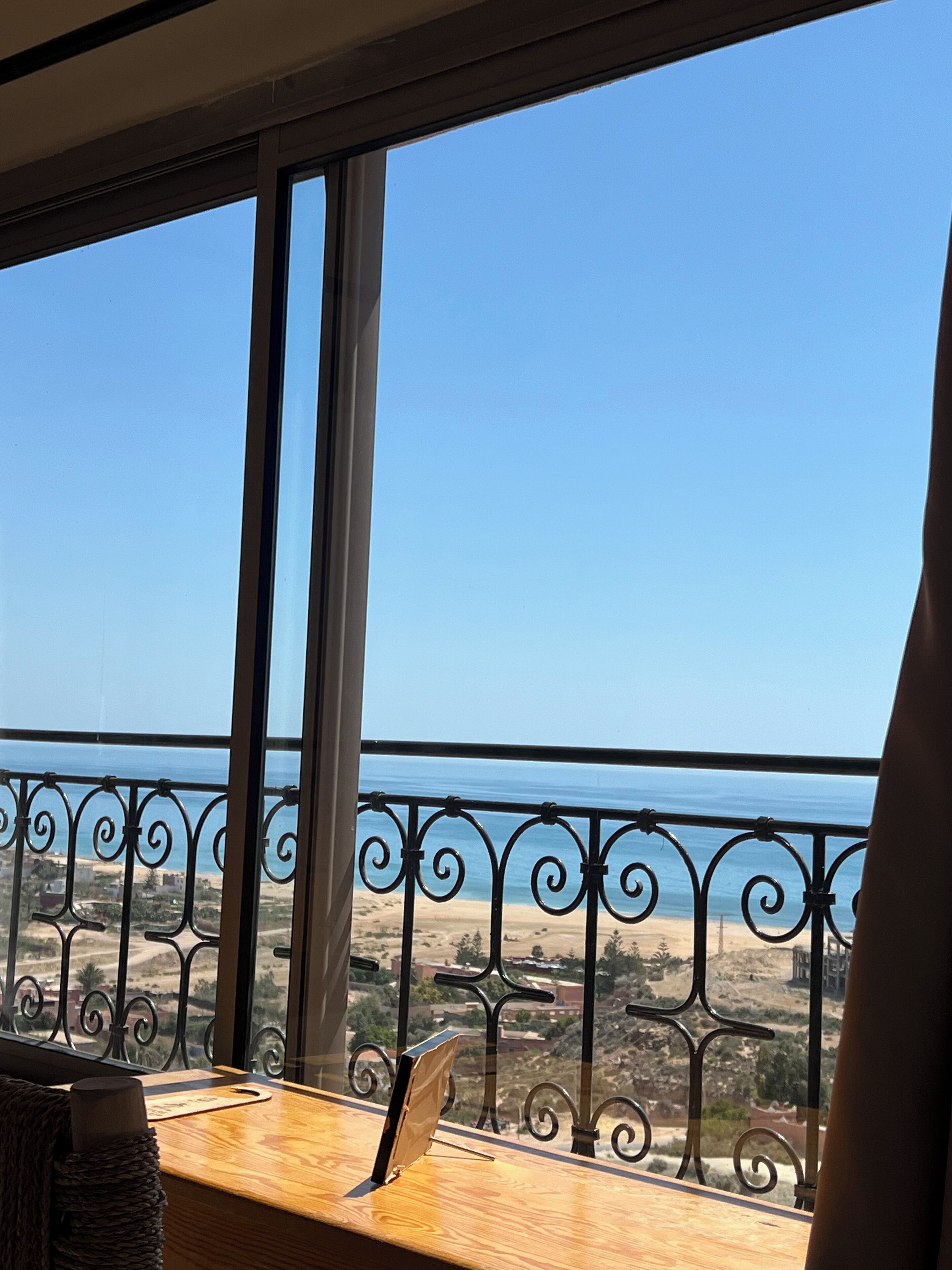 Un balcón con vista al mar y un paisaje arenoso.