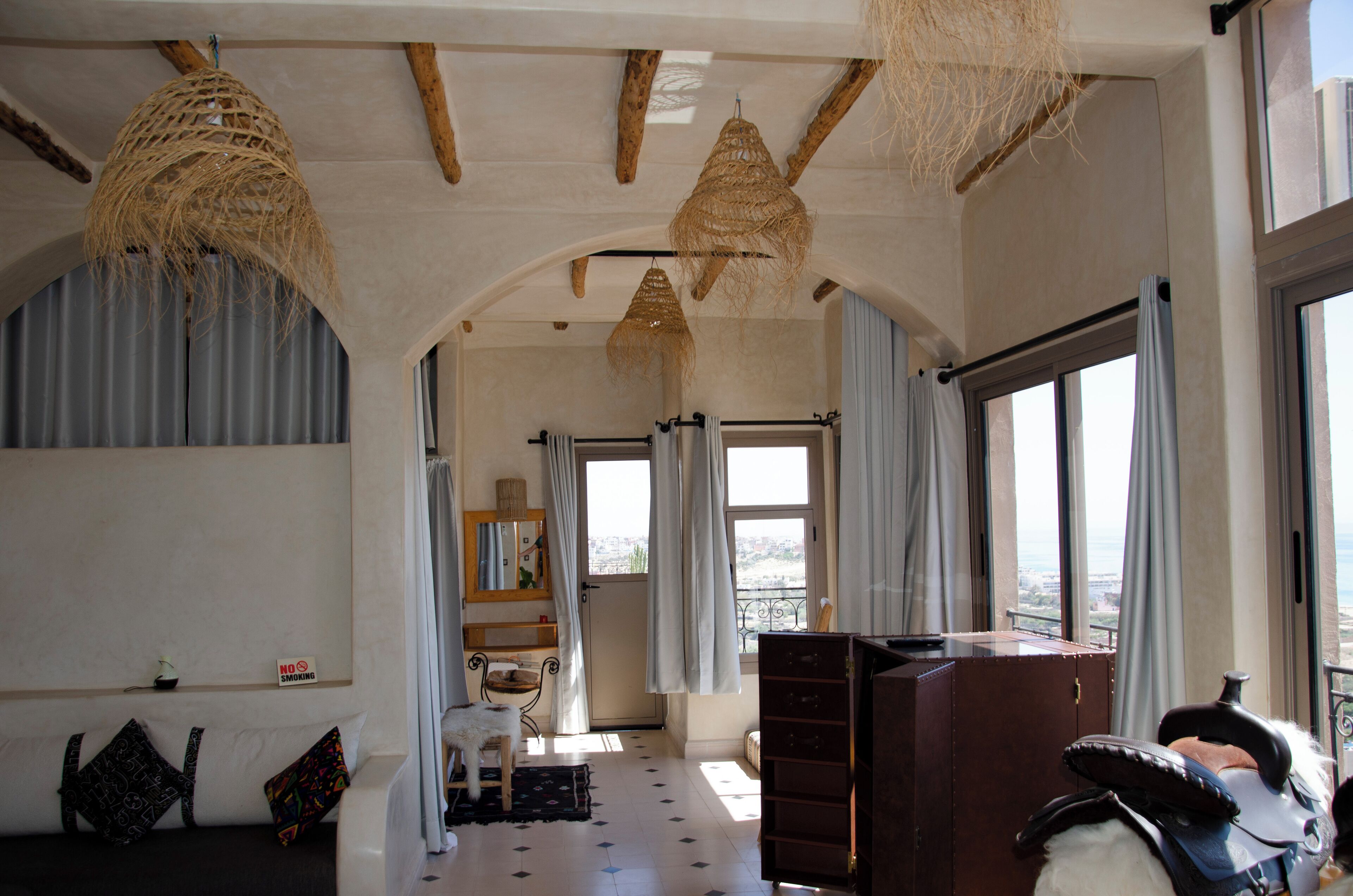 Une pièce spacieuse avec une grande fenêtre, un canapé, un bureau et une chaise.