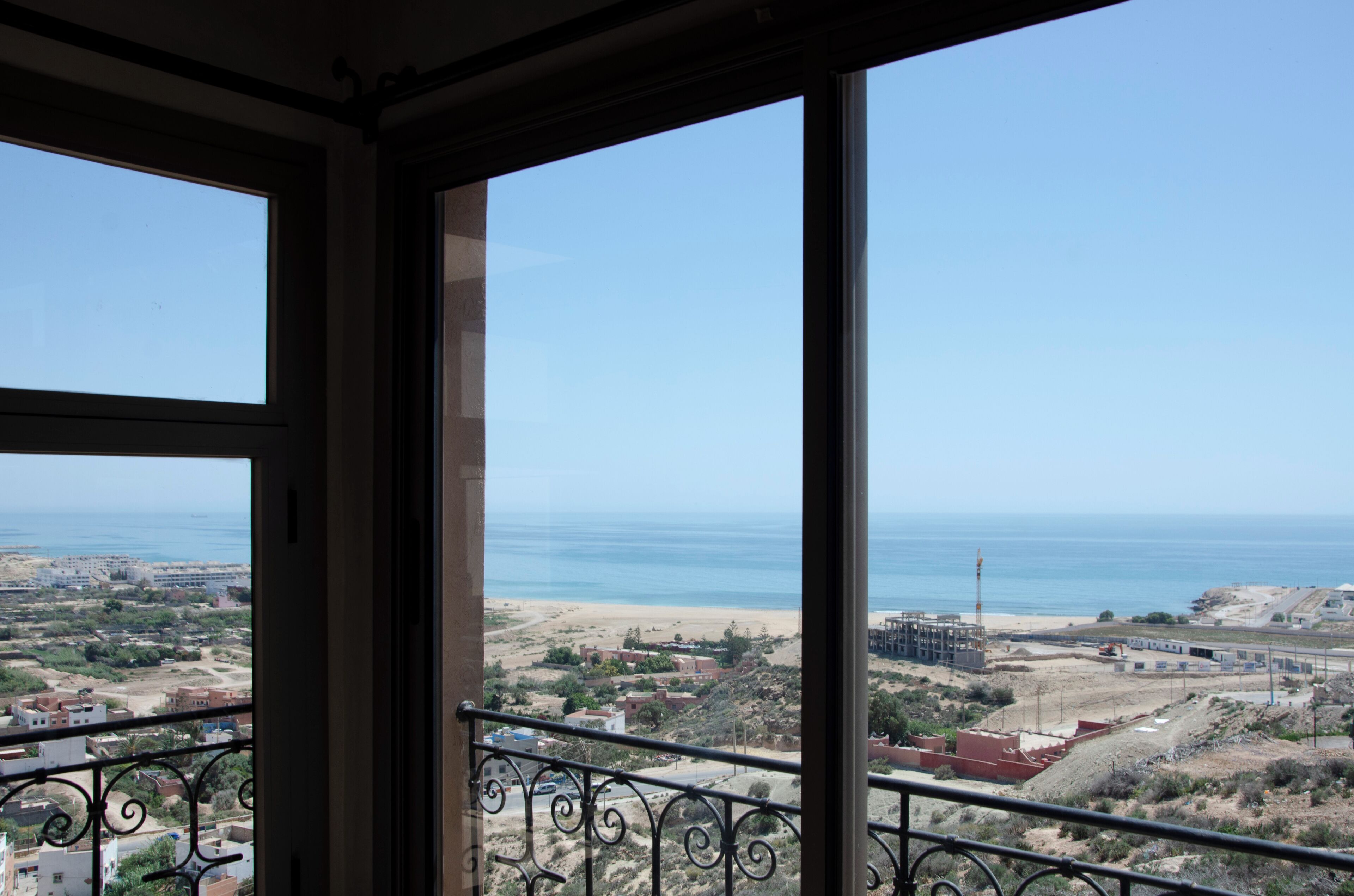A balcony with a view of the beach and ocean.