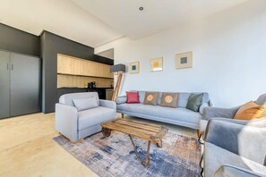 A modern living room with a grey sofa, a wooden coffee table, and a blue rug.