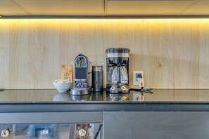 Eine Küchenarbeitsplatte mit Kaffeemaschine, Mixer und Wasserkocher.