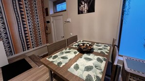 A dining area with a table set for two, a patterned wall, and a window with a view. - One bedroom flat in the center of Riga (Riga)