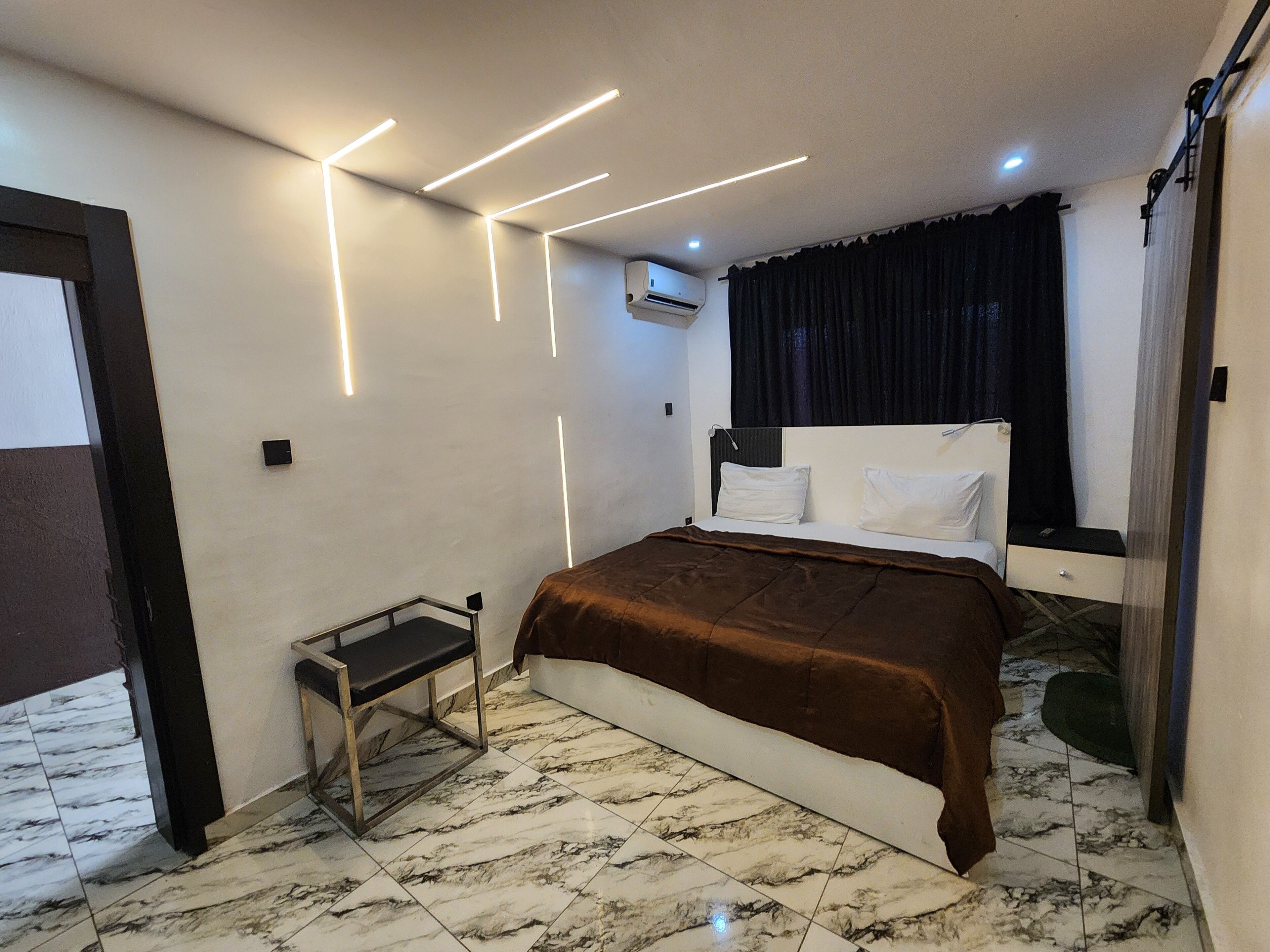 A modern hotel room with a bed, a small table, and a bench.
