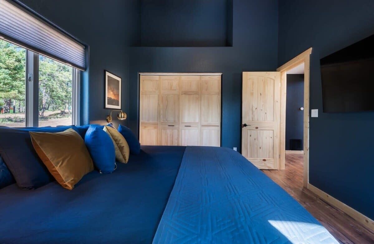 Ein Schlafzimmer mit einem großen Bett, einem Kleiderschrank und einem Fenster.