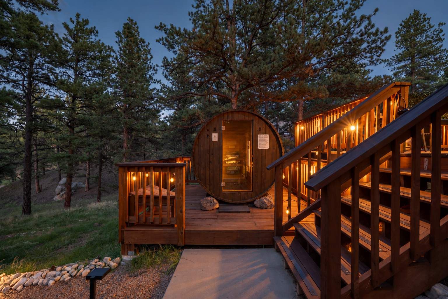 Une cabane en bois dotée d’un intérieur circulaire, d’une terrasse et d’un escalier menant à l’entrée.