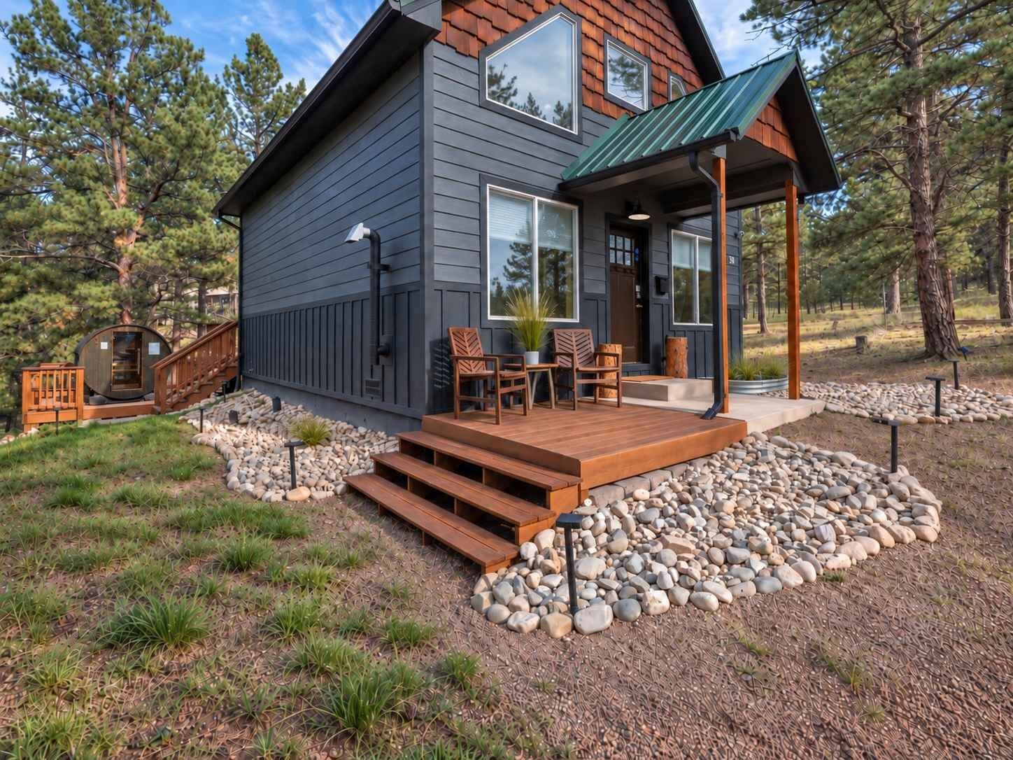 Ein modernes Haus mit einer Holzterrasse, Sitzgelegenheiten im Freien und einem gepflasterten Weg.