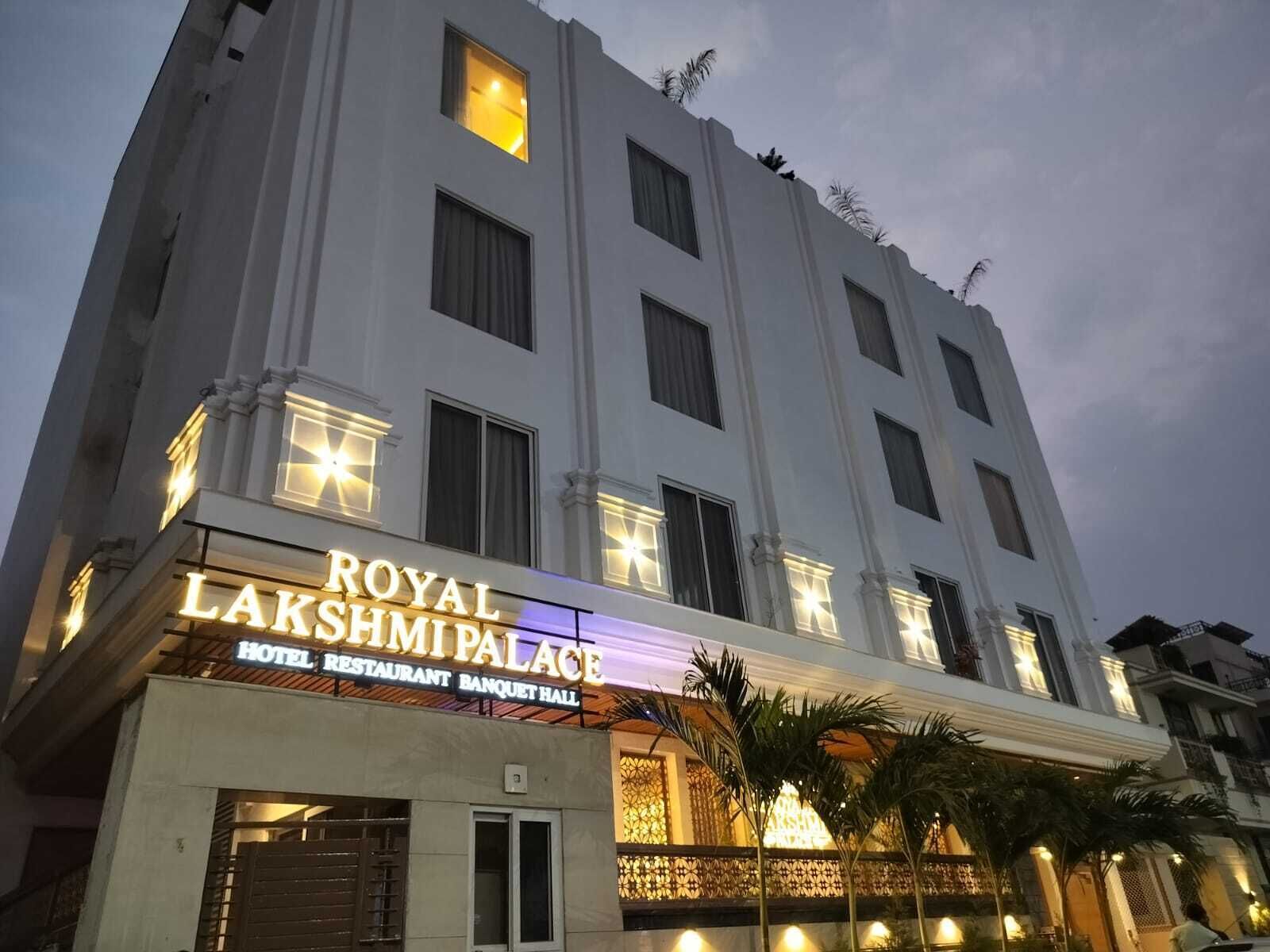 A multi-story building with a sign for "ROYAL LAKSHMI PALACE HOTEL RESTAURANT BANQUET HALL".