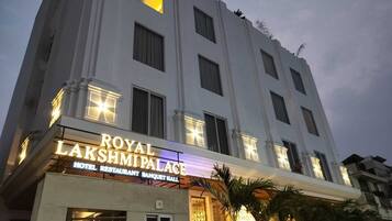 A multi-story building with a sign for "ROYAL LAKSHMI PALACE HOTEL RESTAURANT BANQUET HALL".