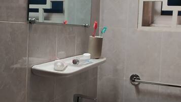 Een douche, handdoeken, zeep, toiletpapier