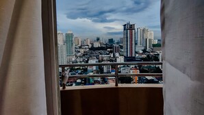 A balcony with a cityscape view, including high-rise buildings and a clear sky. - Birch Tower Manila (Manila)