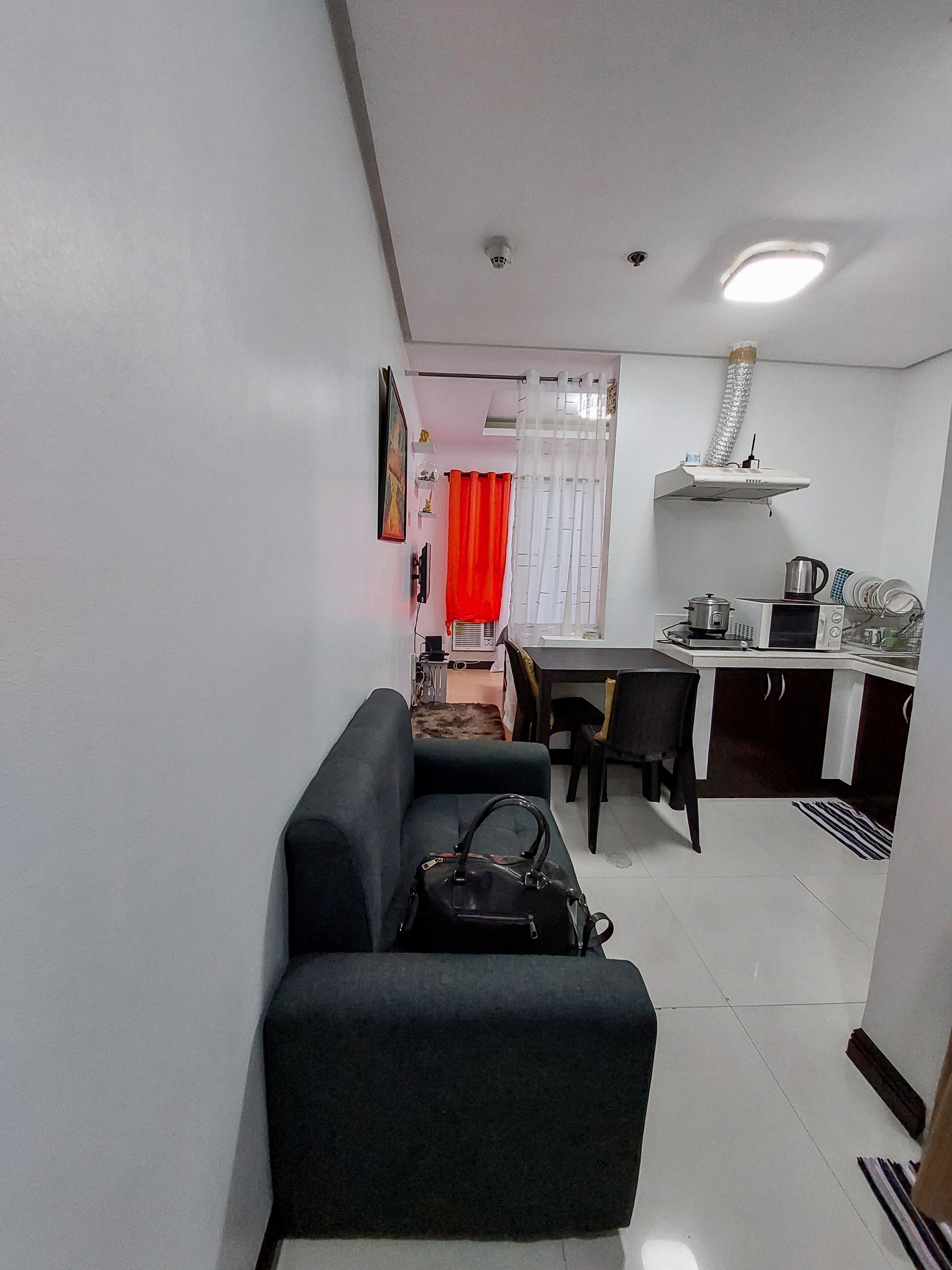 Um espaço compacto com sofá, mesa de jantar e cozinha compacta.