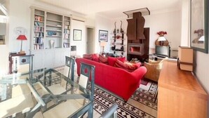 A living room with a red sofa, a glass coffee table, and a fireplace. - Cannes: Duplex 5 bedrooms Apartment with terraces 1 minute from the Palais (Cannes)