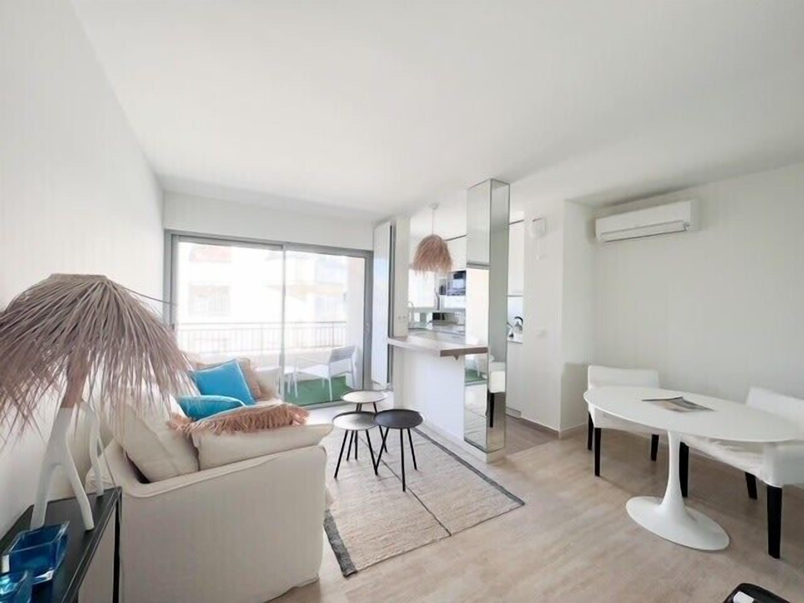 A modern apartment with a living area, dining space, and kitchenette.
