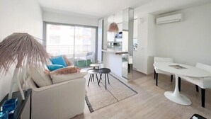 A modern apartment with a living area, dining space, and kitchenette. - Cannes: chic studio quiet in a secure residence 200m from the beaches (Cannes)