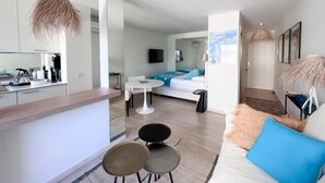 A modern, open-plan living space with a kitchen, dining area, and a bedroom. - Cannes: chic studio quiet in a secure residence 200m from the beaches (Cannes)
