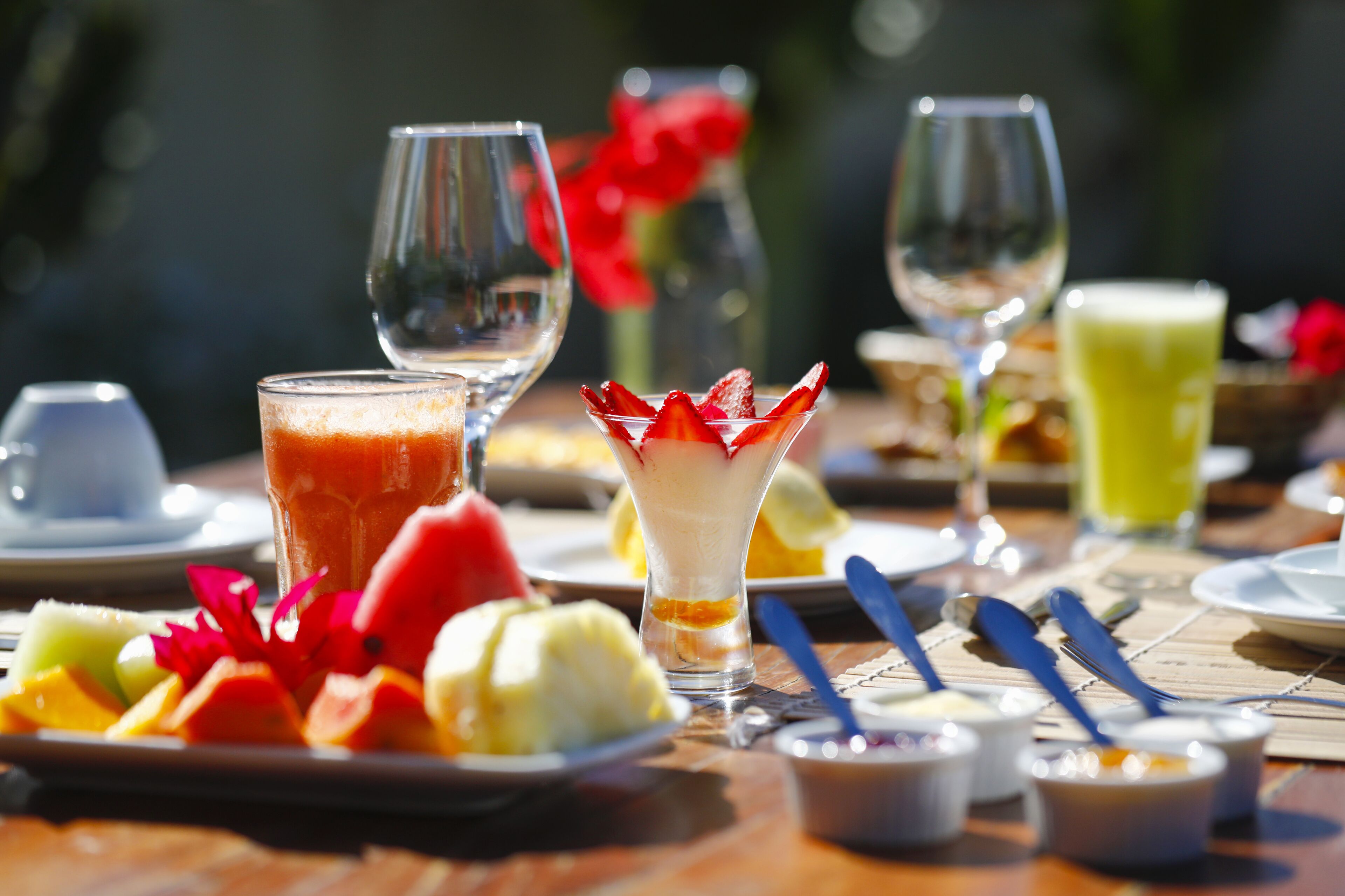 A table set with various dishes, including a fruit salad, a glass of juice, and a dessert.