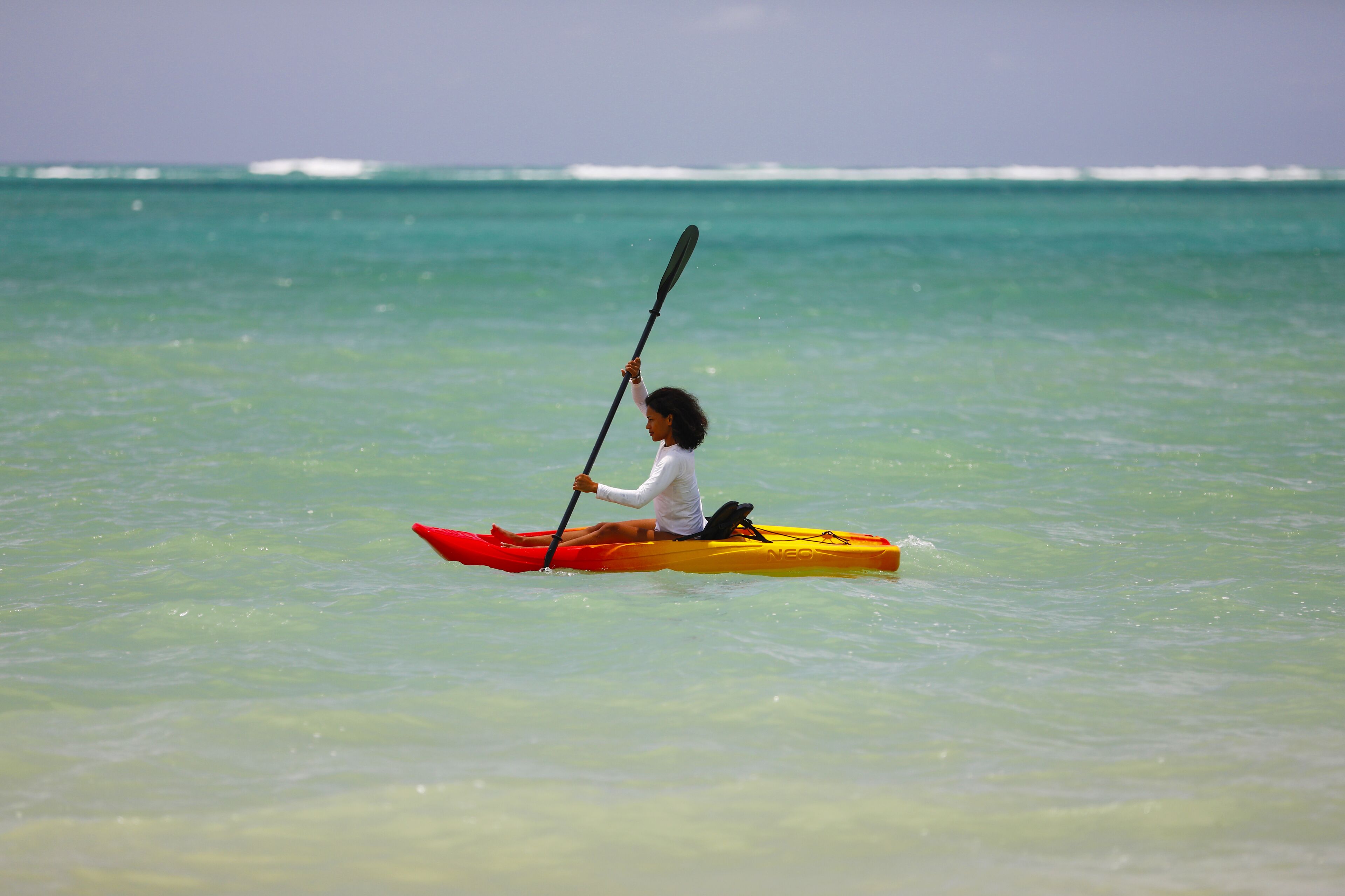 Una persona en kayak sobre aguas tranquilas.