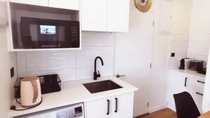 Cocina compacta con microondas, lavavajillas y lavadora.