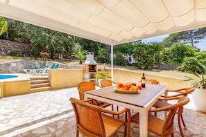 An outdoor patio with a stone pool, wicker furniture, and a barbecue grill. - 3 Bedroom Villa, 300m to the Beach, Cala San Vicente (Cala San Vicente)