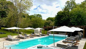 A backyard pool area with lounge chairs, umbrellas, and a hot tub. - 7 bed house in idyllic location with heated pool, hot tub, gym, games room & A/C (Massoulès)