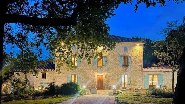A stone building with a gravel driveway leading to a wooden door, surrounded by greenery and trees. - 7 bed house in idyllic location with heated pool, hot tub, gym, games room & A/C (Massoulès)