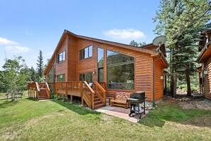 A wooden cabin with a deck, a barbecue, and a satellite dish. - Fall River Retreat - Monthly Long-term Vacation Rental 3 Bedroom Townhouse by RedAwning (Estes Park)