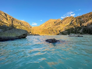 Ein Fluss, der durch eine gebirgige Landschaft mit Felsformationen und dichten Wäldern fließt.