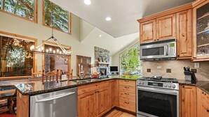 A spacious kitchen with wooden cabinets, stainless steel appliances, and a large island with a refrigerator.