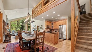 A spacious kitchen with wooden cabinets, a central island, and a stainless steel refrigerator.