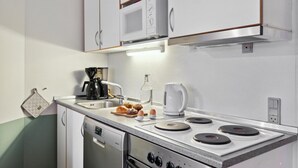 Cuina compacta amb microones, cafetera, bullidor i rentavaixelles.