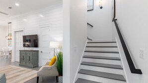 Ein modernes Interieur mit Treppe, Essbereich und Wohnzimmer.