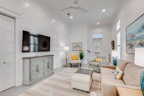 A spacious living room with a large flat-screen TV, a white sofa, and a beige armchair. - BVR 30 - Whim by the Beach by Liquid Life (Orange Beach)