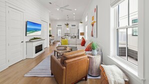 Un sal ón espacioso con chimenea, televisor y ventana grande.