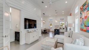 A spacious living area with a large TV, dining table, and comfortable seating.