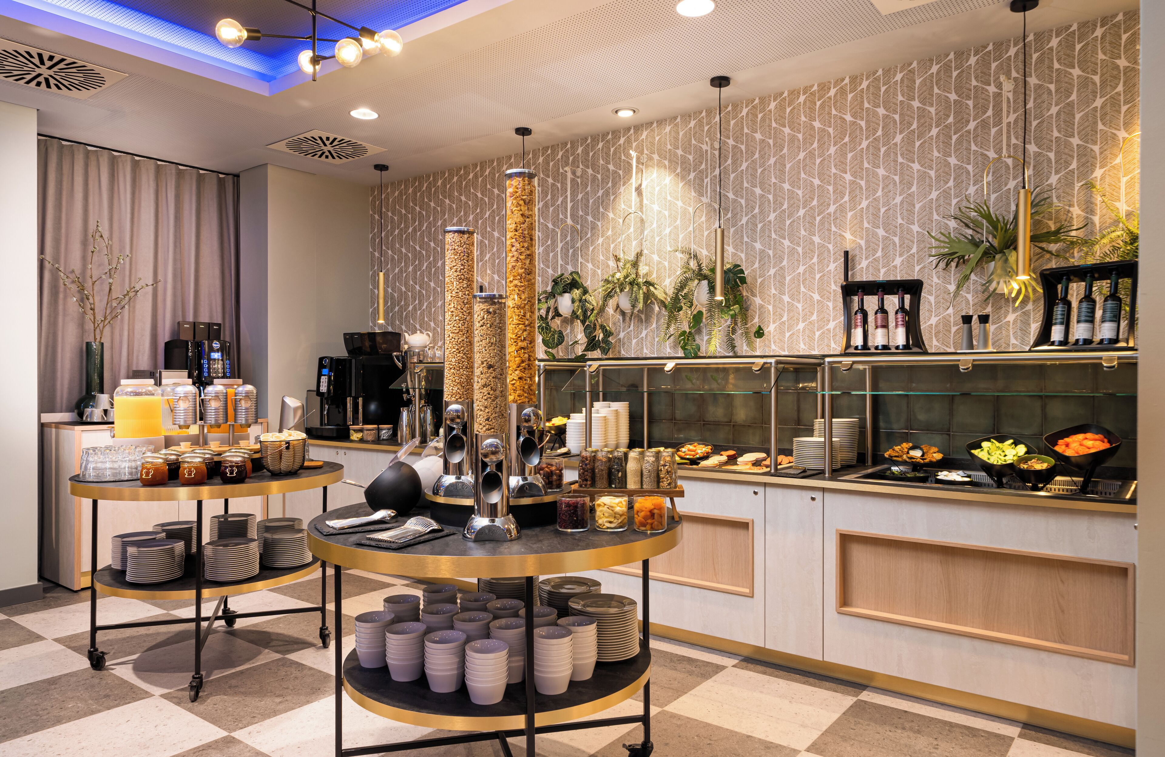 A modern breakfast bar with a variety of food items, a coffee station, and decorative plants.
