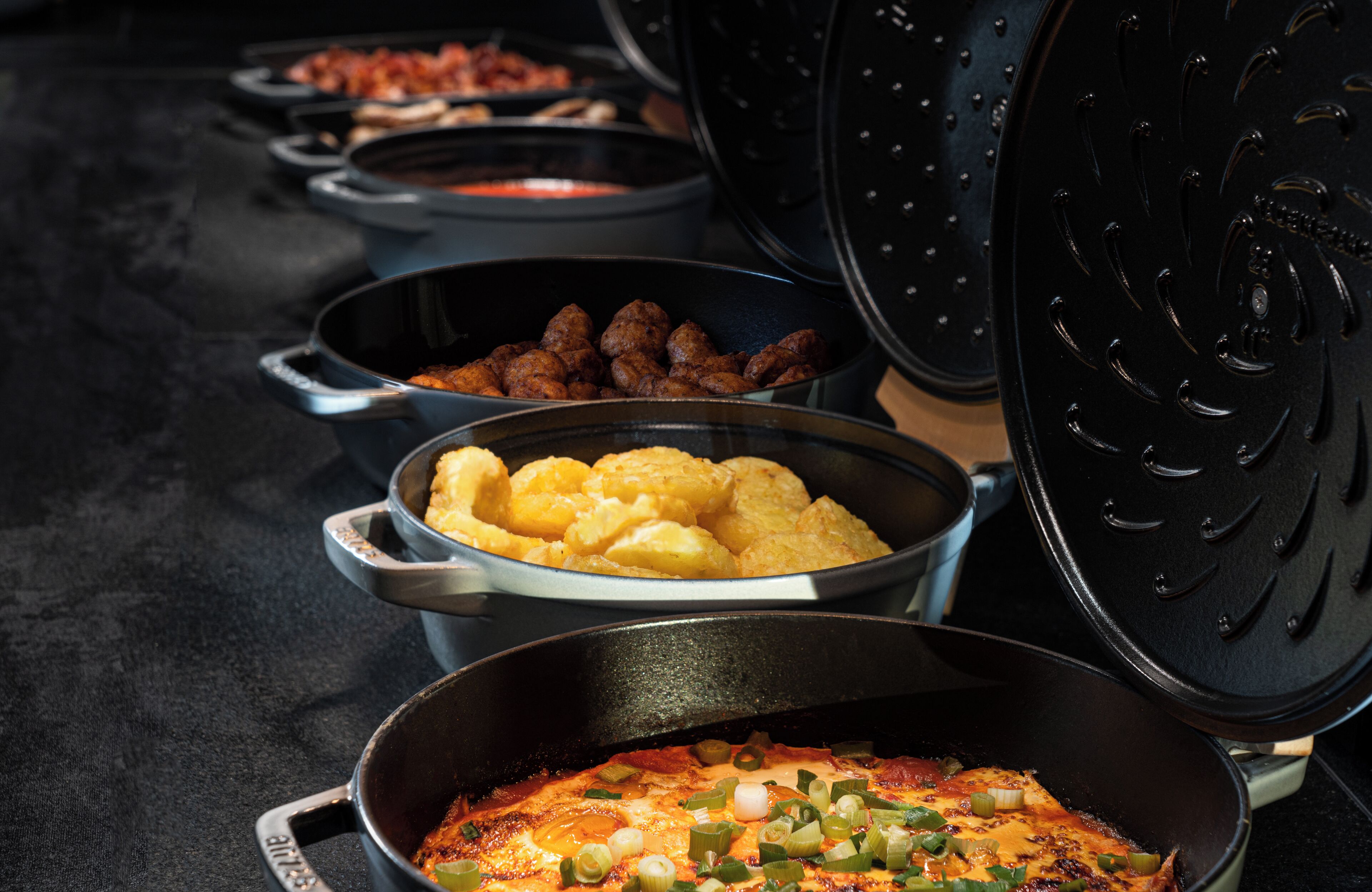 A buffet with various dishes including fried items, potatoes, and a casserole.