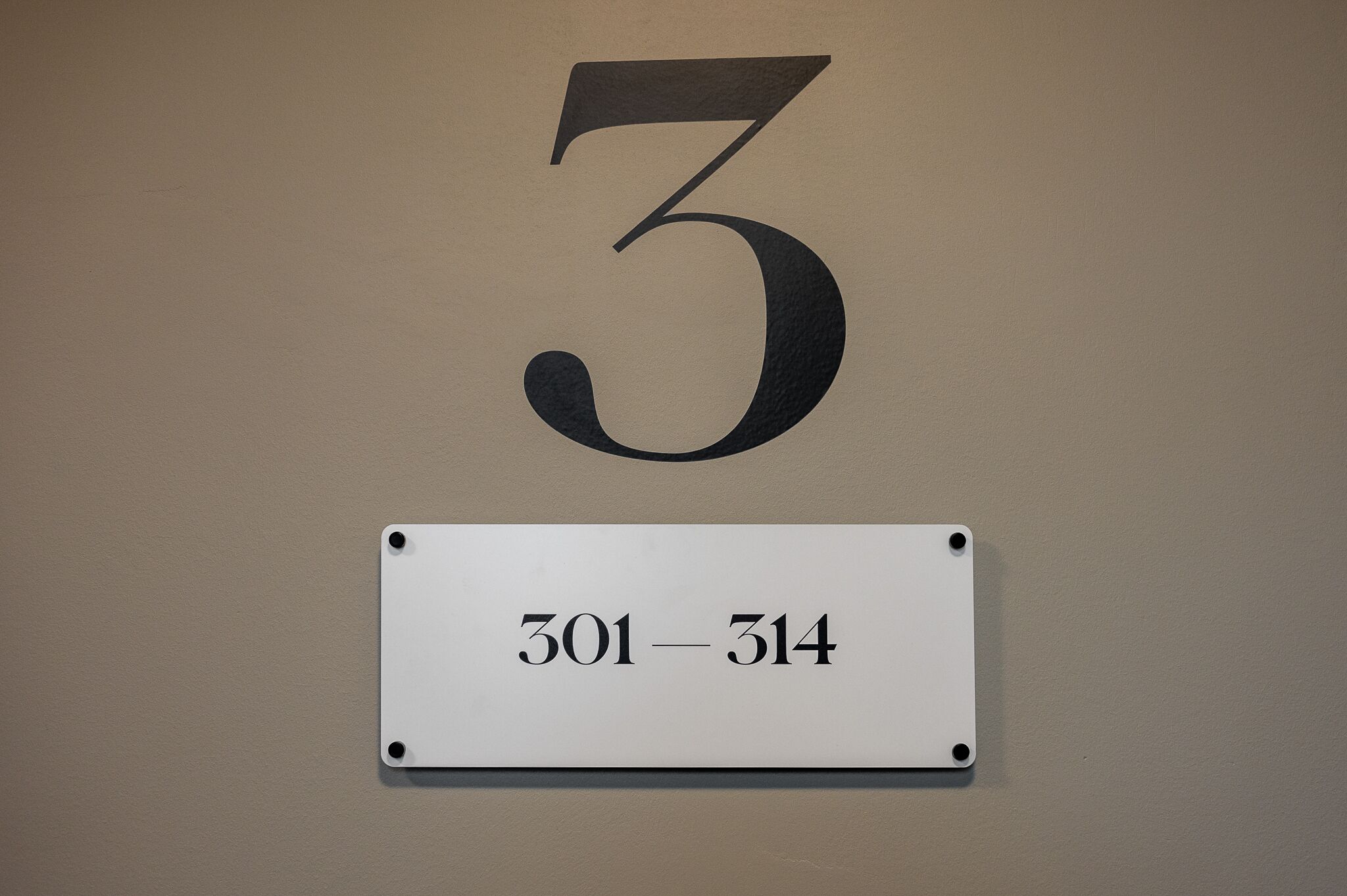 A wall with a large number '3' and a sign below it indicating room numbers '301-314'.