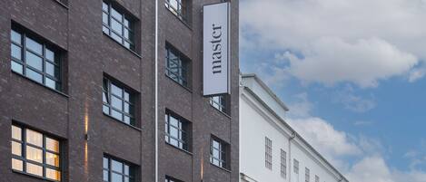 A modern building with a sign reading "master" on a vertical banner.