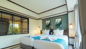 Quarto de hotel com uma cama grande, duas mesas de cabeceira, uma janela com vista e luminárias fixadas na parede.