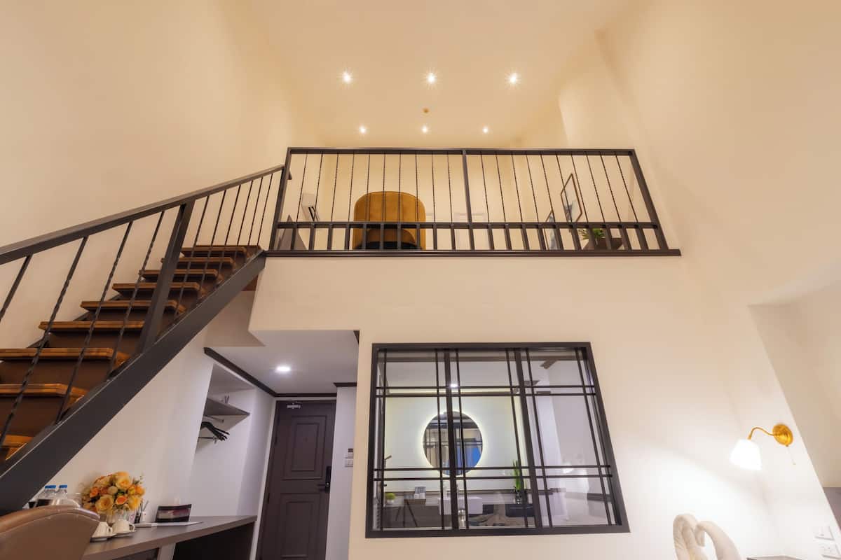 A staircase with a black railing leading to a second floor.