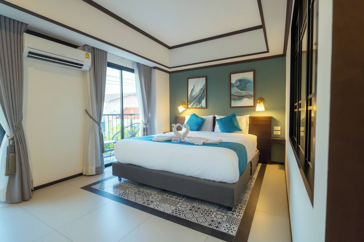 A hotel room with a large bed, a balcony, and a view of the outside.